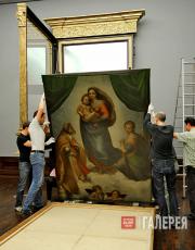 Gallery assistants lift the Sistine Madonna to hang it in its new hand-crafted f